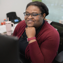 Craft team member smiling while working at her desk