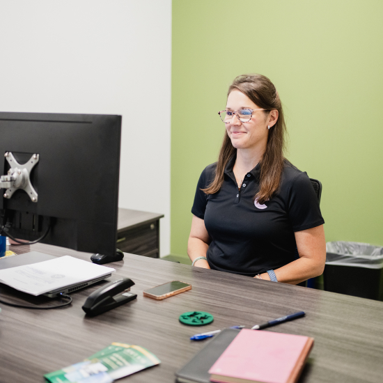 Craft team member smiling while working at her desk