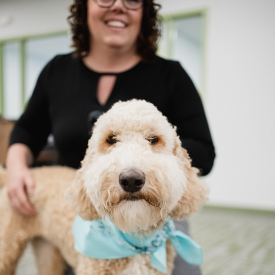 Craft team member petting their dog and smiling