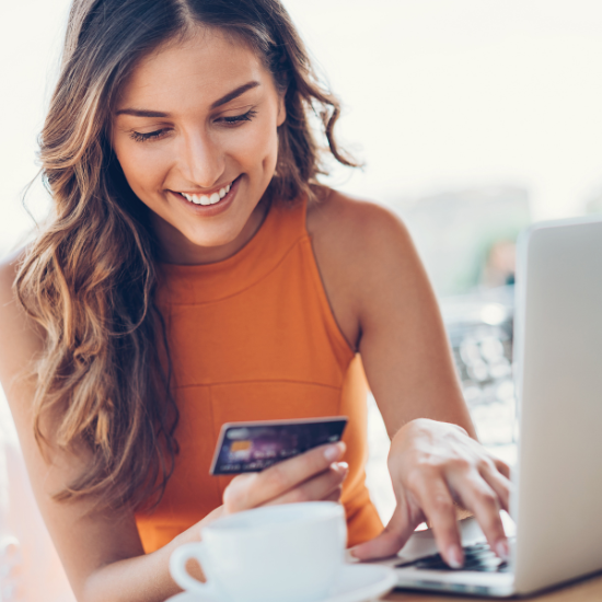 woman looking at credit card in coffee shop