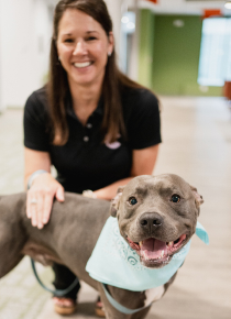 Craft team member petting their dog and smiling