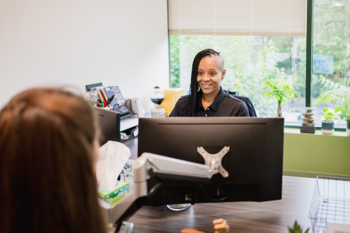 Craft team member smiling while working at her desk with a customer