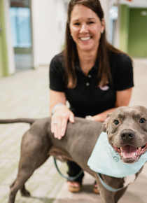 Craft team member petting their dog and smiling