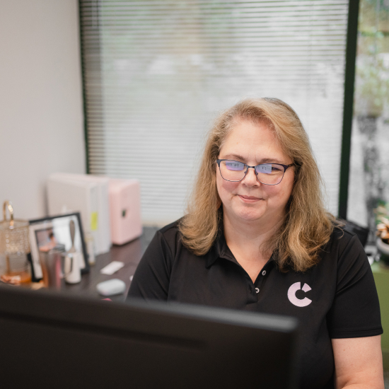 Craft team member smiling while working at her desk