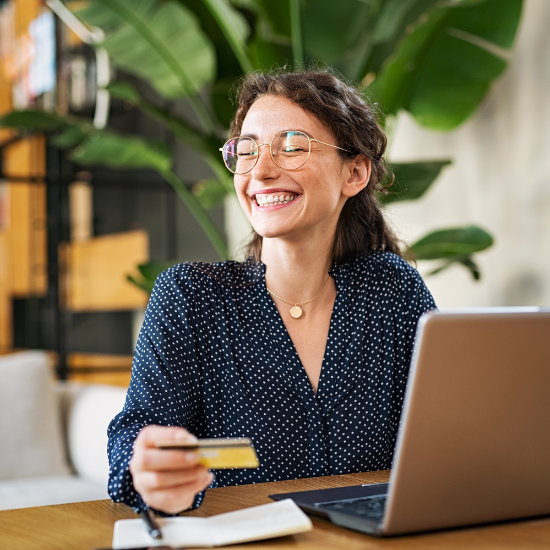 woman smiling and holding credit card in office 