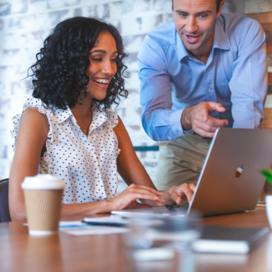 man and woman looking at computer