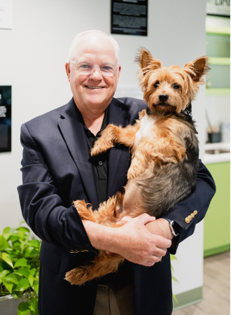 Craft team member holding their dog and smiling