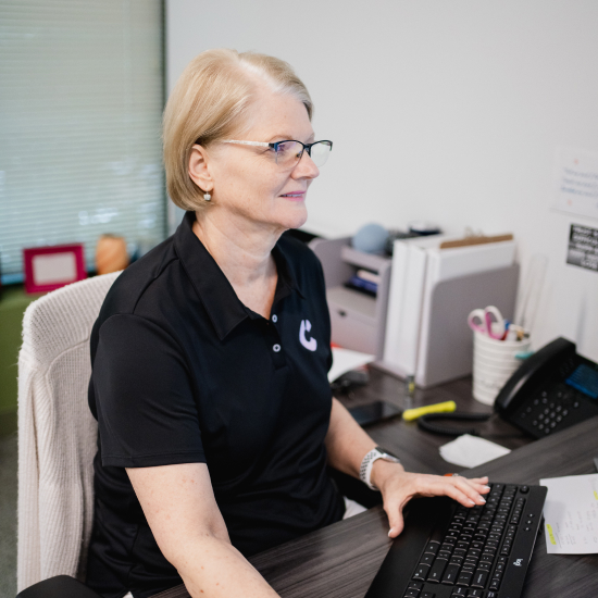 Craft team member smiling while working at her desk